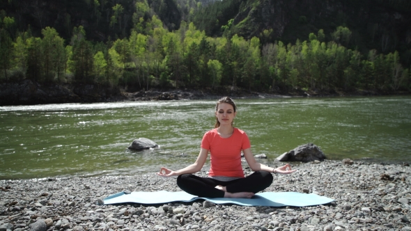 Young Woman Is Practicing Yoga At Mountain Lake