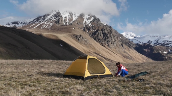 Woman Setup a Tent In The Mountains