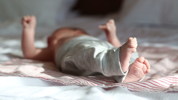 Newborn Baby Lying On a Bed