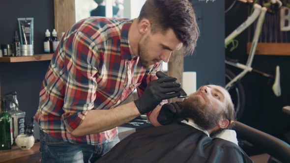 Barber Trimming Man's Beard