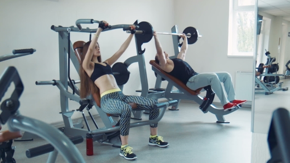 Fit Couple Doing Chest Exercise In Gym