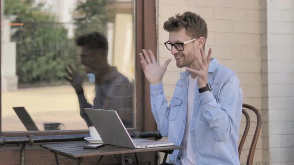 Online Video Chat by Young Man on Laptop, Sitting Outdoor