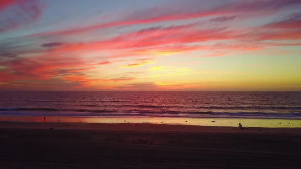 Aerial drone view of a sunset at the beach over the ocean.