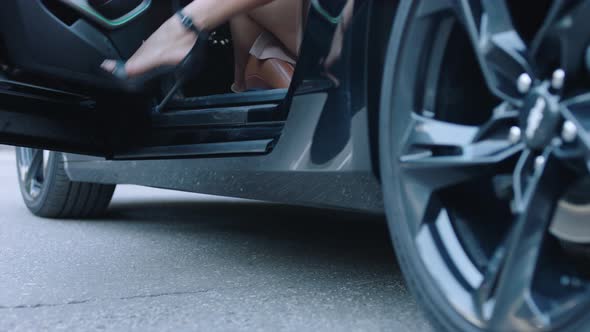 Sexy Woman is Getting Out of the Sport Car Female Legs Wearing Stilettos