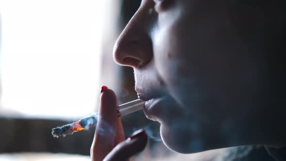 Close Up of Young Woman Smoking Medical Marijuana Joint
