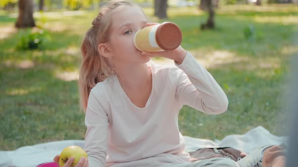 Cute Schoolgirl Having Lunch in Park