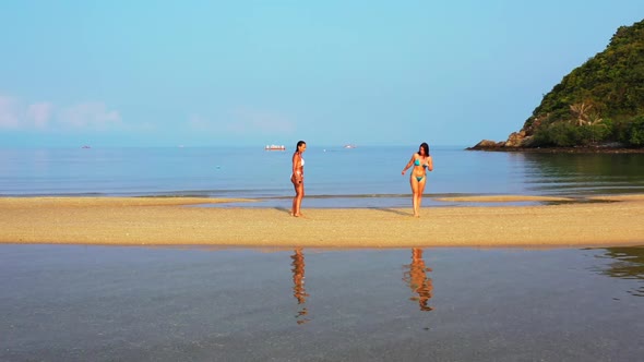 Tourists tan on paradise seashore beach wildlife by shallow ocean with white sand background of Thai