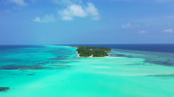 Daytime flying copy space shot of a white sandy paradise beach and blue sea background in 4K