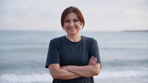 Portrait of Smiling Middle Aged Woman Looking at Camera on Beach