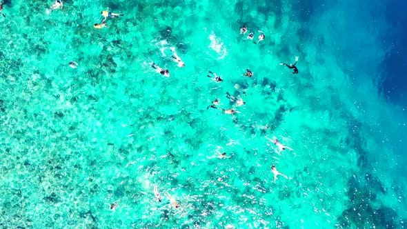 Wide overhead clean view of a white sandy paradise beach and blue ocean background in colourful 