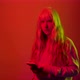 Studio shot young blonde caucasian woman on red background using smartphone looking in camera - VideoHive Item for Sale