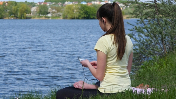 Young woman is meditated and listened music 