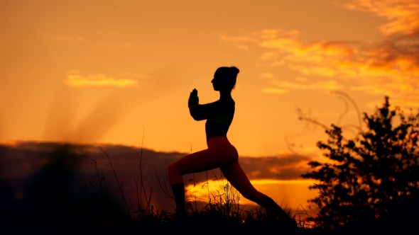 Silhouette Of a Fitness Woman Profile Stretching At Sunriset