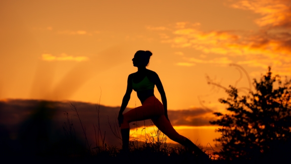 Silhouette Of a Fitness Woman Profile Stretching At Sunriset