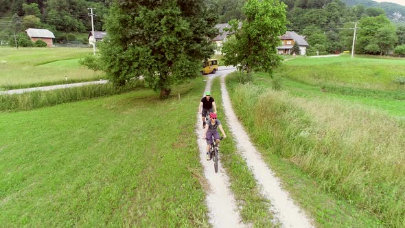 Aerial view of a couple riding a mountain bike on the forest trail in Slovenia.