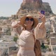 A Woman Takes a Selfie on the Background of the City with the Ortahisar Fortress - VideoHive Item for Sale