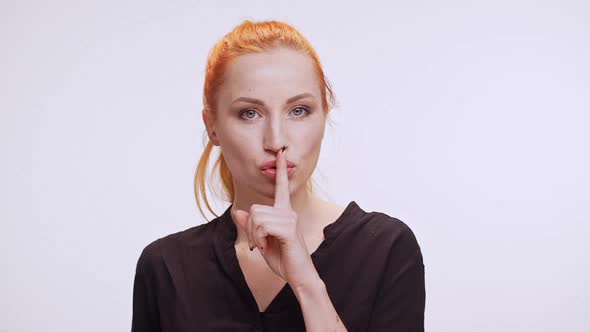 Beautiful Middleaged Caucasian Woman with Orange Colored Hair and Dark Brown Shirt Standing on White