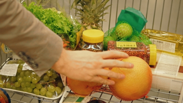 Male Hand Putting Fruit In A Shopping Trolley, Healthy Food Concept
