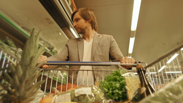 Handsome Man Shopping In A Supermarket, View From Shopping Trolley