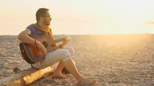 Young Boy Plays Guitar At Sunset