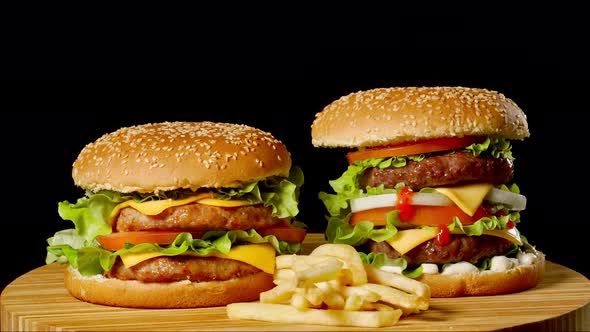 Two Craft Beef Burgers on Wooden Table Isolated on Dark Grayscale Background