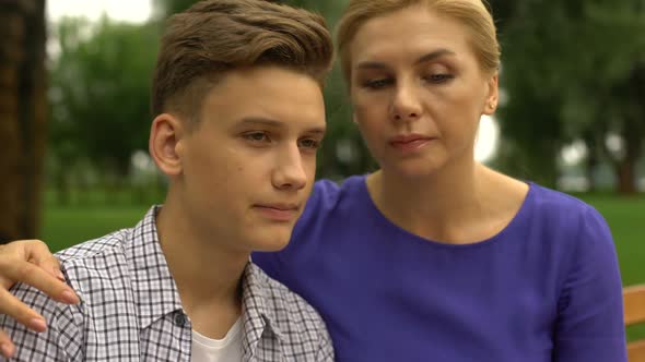 Young Son in Despair Putting Head on Mothers Shoulder Feeling Calmness and Love