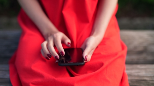 Woman In Red Dress Holding a Phone With App Mobile Wallet