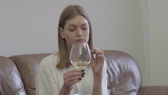 Sad Woman Holding Wedding Ring Under the Wine Glass