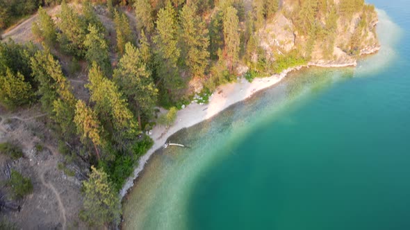 Turquoise water and white rocks on the shore of kalamalka lake in the Okanagan. 4k aerial footage go