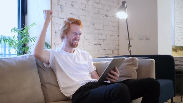 Reaction to Success by Man Using Tablet in Office