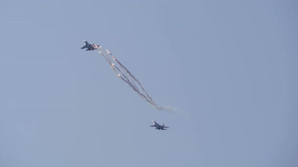 Supersonic Planes in the Blue Sky Perform Aerobatics. The Plane Releases Fireworks