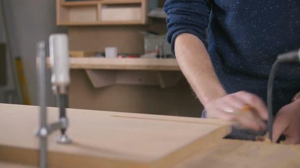 Young Man Working As Carpenter and Measuring Board