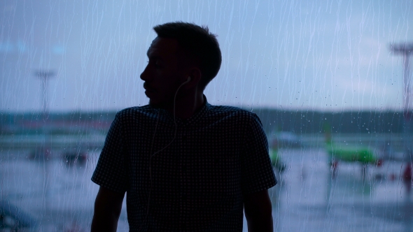 Silhouette Of a Young Man At The Airport Against The Window.