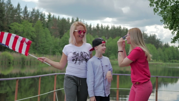 People Smiling And Waving To Camera With US Flag alt