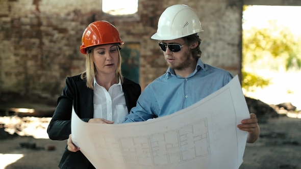 Builder in Hard Hats Discussing Architectural Design Engineer