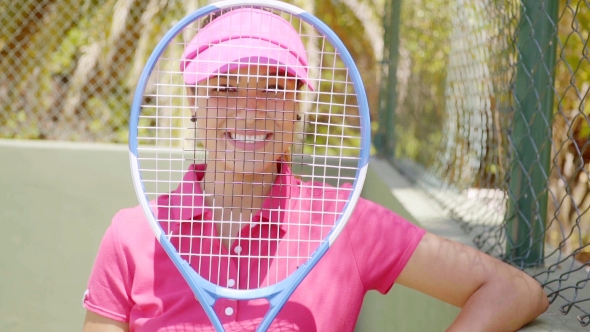 Happy Tennis Player Smiling Through Her Racket