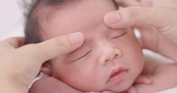Close Up Shot Hands Of Mother Massaging Sleeping Baby Carefully.