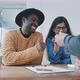 Agent handing over car keys two multi-ethnic couple sitting at a table - VideoHive Item for Sale