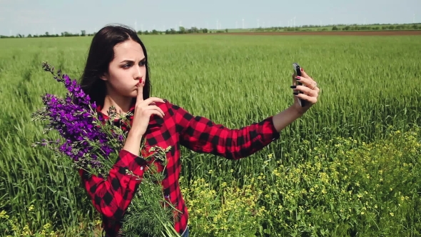 Young Woman Brunette With a Bouquet Of Wildflowers Makes Selfie.