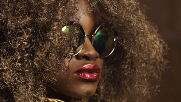 Magic Golden African American Female Model In Massive Sunglasses With Bright Glitter Makeup