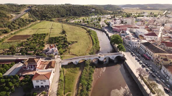 Aerial dolly shot over the historic town of Silves in Portugal, showing the river and bridge