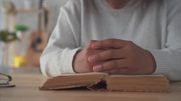 African American Woman with an Afro Hairstyle Recites a Prayer with a Bible in a Modern Apartment