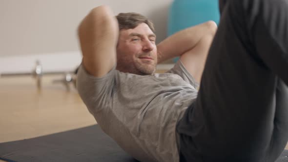 Positive Strong Sportsman Pumping Press Looking at Camera and Showing Thumb Up Winking