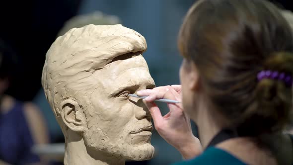 Woman Sculptor at Work on a Sculpture of a Human Head