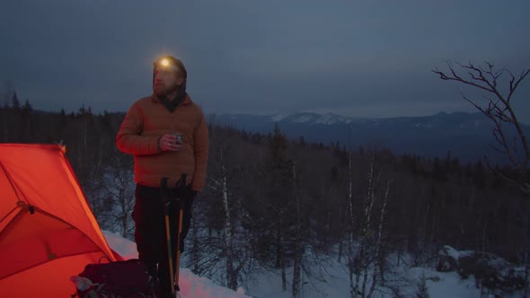 Man Standing by Tent at Campsite on Mountain Top