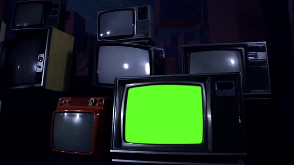 Retro TV Set turning On Green Screen among Many Vintage Televisions. Dolly.