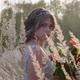 A Young Woman Dressed in a Gray Wedding Dress. She Has Flowers in Her Hand and Is in the Park. - VideoHive Item for Sale