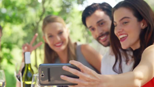 Group of friends taking selfie while having lunch