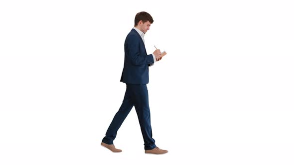Thinking Businessman Writing Notes in His Notebook While Walking on White Background