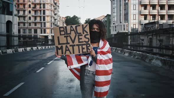 Africanamerican Protester in Black Bandana Wrapped in Flag of USA